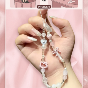 Hand holding a premium 3D pink Hello Kitty phone chain strap with white pearls and a cute ribbon lanyard against a wooden background.